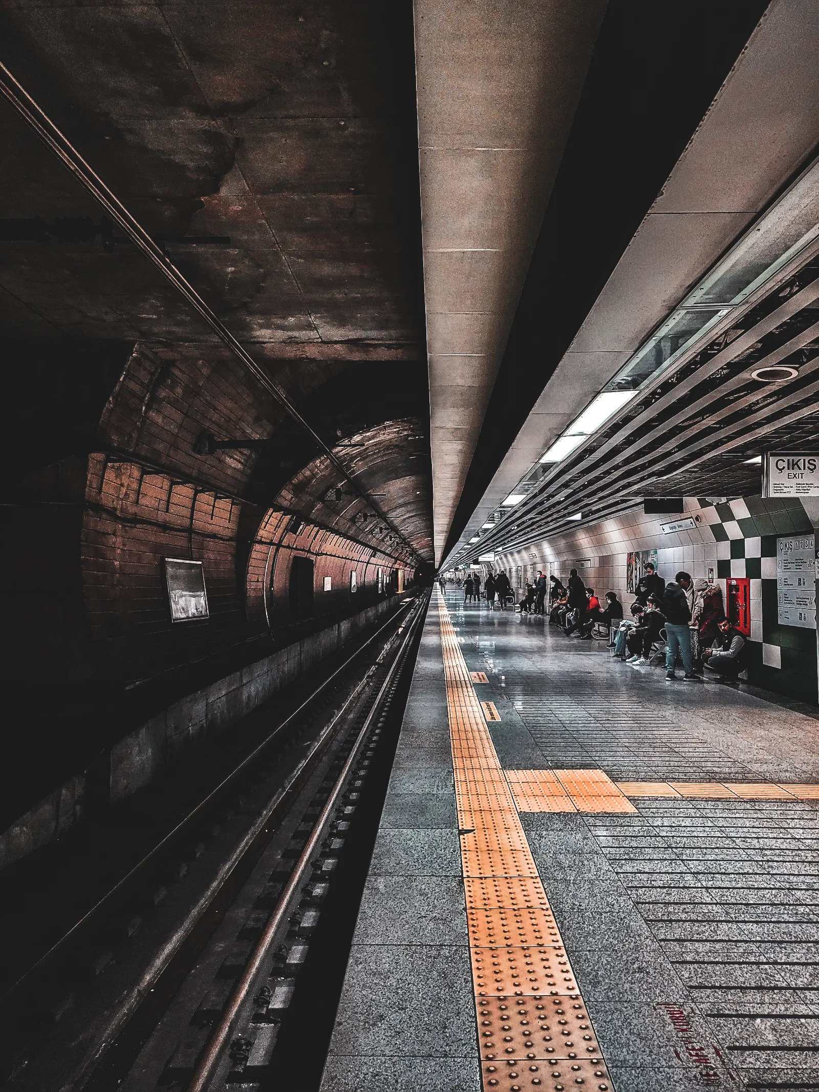 Metro platform with tunnel curving into the dark