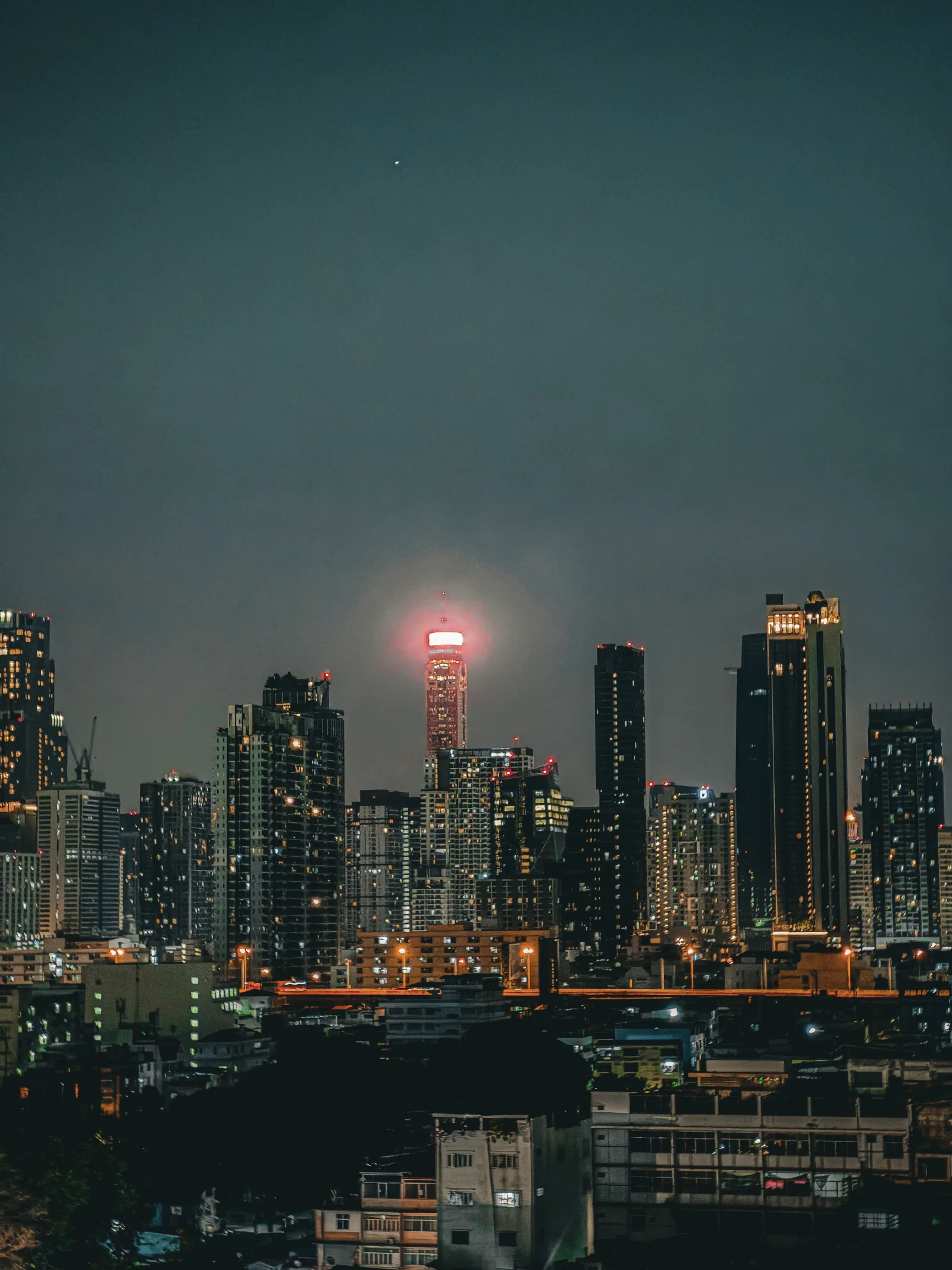 City skyline at night with a red-lit tower