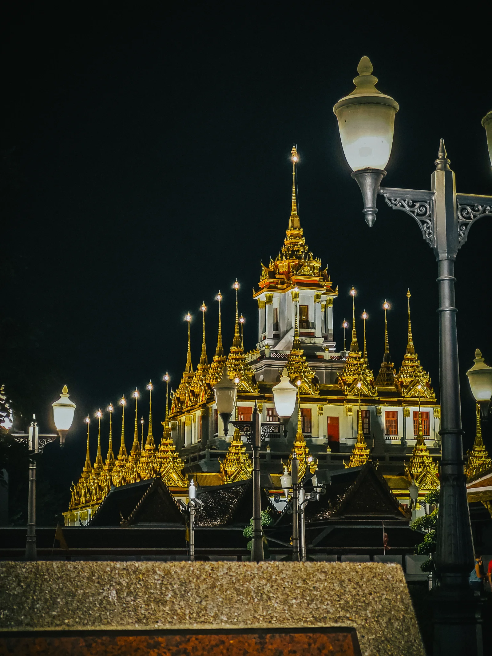 Gilded temple spires lit against a black sky