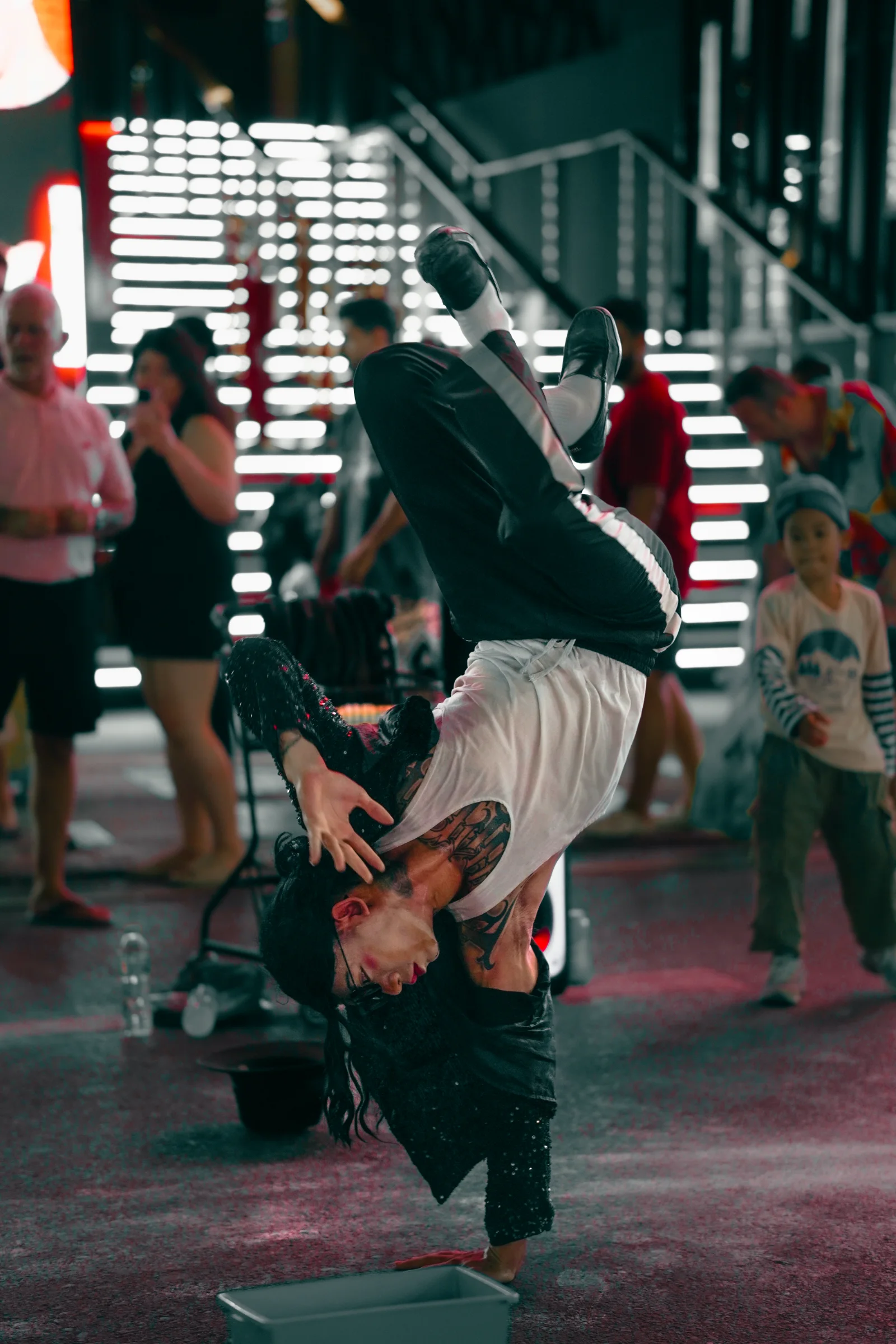 Street performer mid-handstand at night